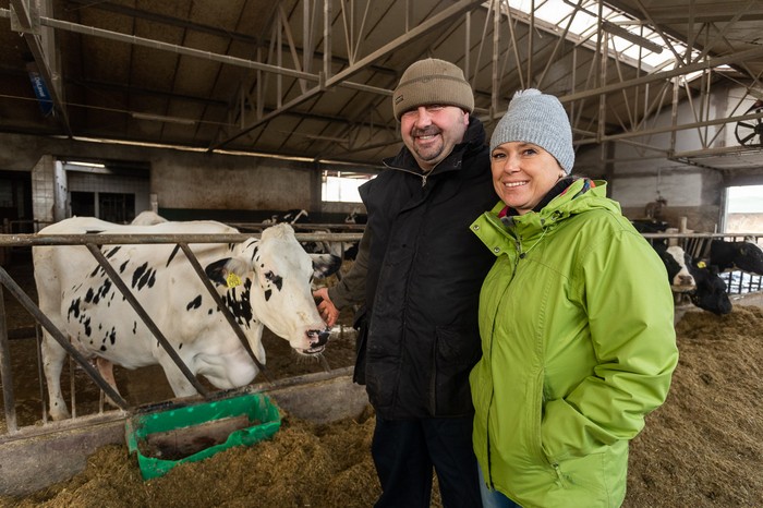 Artur Saganowski z żoną przy jednej ze swoich krów stojących w oborze, fot. Filip Kowalkowski dla UMWKP