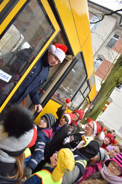 W drzwiach żółtego autobusu stoi przebrany za Św. Mikołaja policjant; foto - Jacek Knychała