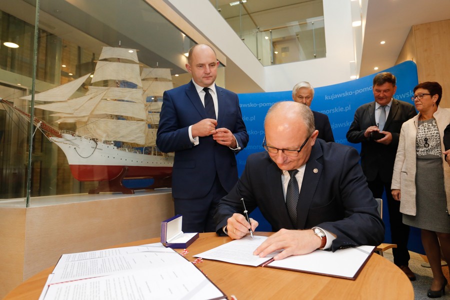 Podpisanie porozumienia w sprawie uruchomienia przeprawy promowej odbyło się przy modelu Daru Pomorza w holu Urzędu Marszałkowskiego, fot. Mikołaj Kuras