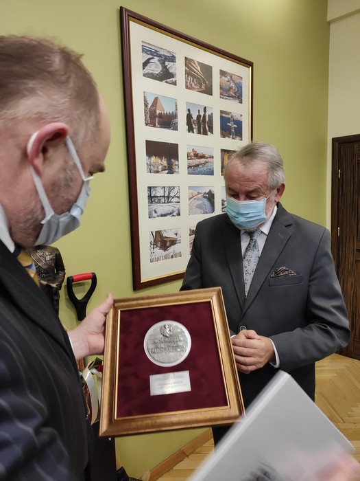 Marszałek Piotr Całbecki przekazuje medal synowi pani Anieli Mikołajczak, fot. UMWKP