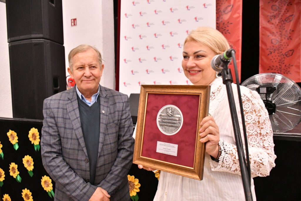 Andrzej Schmidt odbiera medal Unitas Durat z rąk przewodniczącej Elżbiety Piniewskiej, fot. Bartosz Czaplickiego/UMWKP