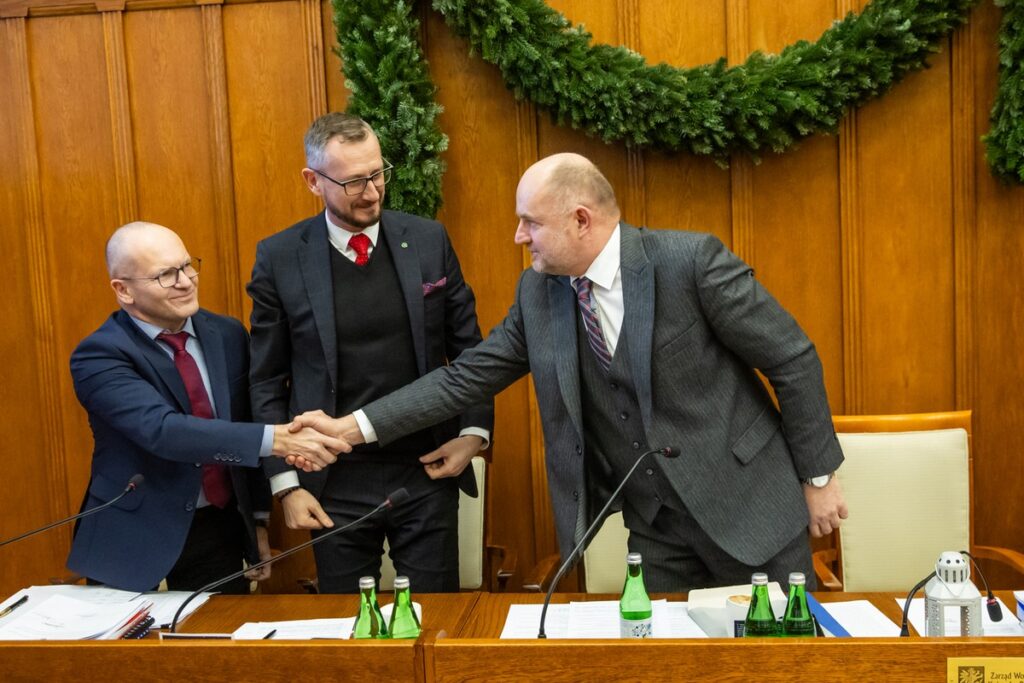 Gratulacje po przyjęciu budżetu województwa; stoją od prawej: marszałek Piotr Całbecki, członek zarządu województwa Dariusz Kurzawa i skarbnik województwa Paweł Adamczyk, fot. Andrzej Goiński/UMWKP