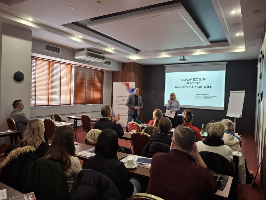 Dorota Piekarek - kierownik Biura Wsparcia Rodziny, Przeciwdziałania Przemocy i Uzależnieniom w Departamencie Spraw Społecznych Urzędu Marszałkowskiego Województwa Kujawsko-Pomorskiego w Toruniu, Sylwester Lewandowski - prowadzący szkolenie pn. „Sprawdzam i chronię – alkohol tylko dla 18+”, oraz uczestnicy szkolenia w Hotelu Filmar w Toruniu, fot. Biuro Wsparcia Rodziny, Przeciwdziałania Przemocy i Uzależnieniom