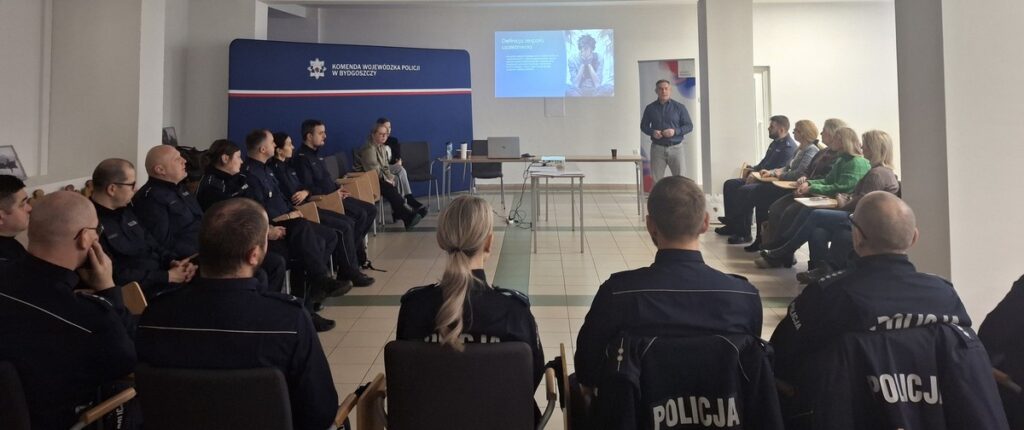 Kornel Jarzębiński - prowadzący szkolenie pn. „Policjant wobec uzależnienia – interwencja, pomoc i wsparcie dla osób uzależnionych i ich rodzin” oraz uczestnicy szkolenia w Komendzie Wojewódzkiej Policji w Bydgoszczy, fot. Biuro Wsparcia Rodziny, Przeciwdziałania Przemocy i Uzależnieniom