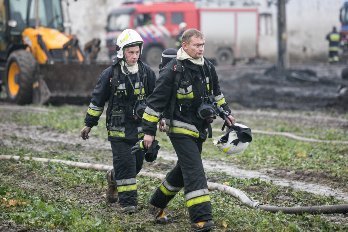 Dwoje strażaków idący przez pole podczas akcji w Raciniewie