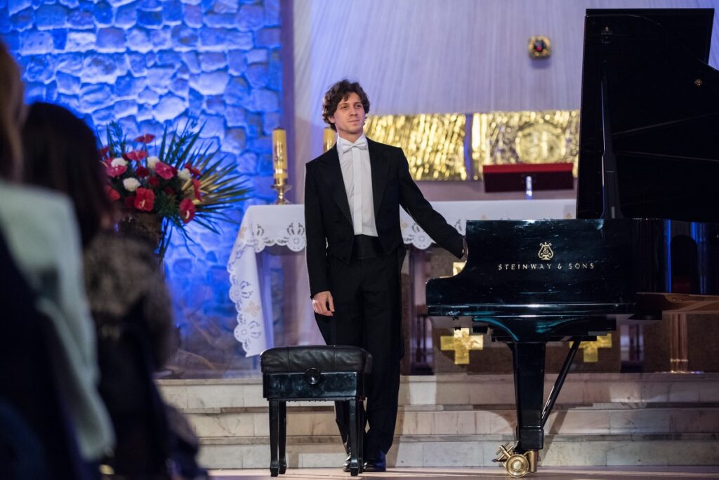 Rafał Blechacz stojący przy fortepianie