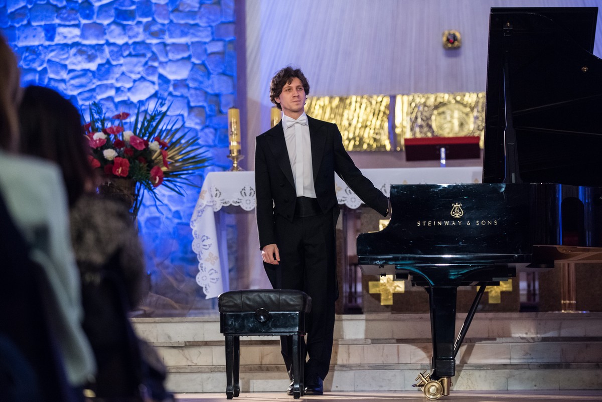 Rafał Blechacz stojący przy fortepianie