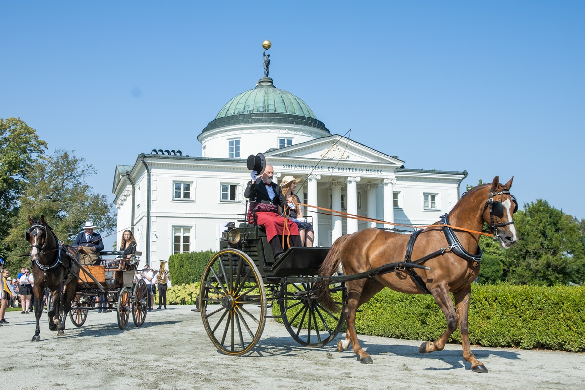 Two horse-drawn carriages against the background of the Palace in Lubostroń during the show