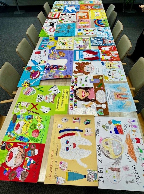 Rozłożone na stołach prace konkursowe.