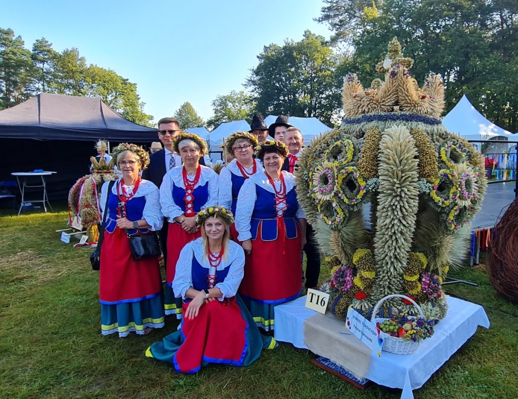 Wieniec tradycyjny z powiatu lipnowskiego z osobami prezentującymi region w stronach ludowych